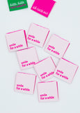 Soft-pinkfarbenes Webetikett mit dem Schriftzug "smile for a while" in weißer Schrift. Ein charmantes Label, das ein Lächeln auf jedes Kleidungsstück zaubert.