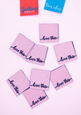 Zartrosa Webetikett mit dem Schriftzug "love this". Perfektes Weblabel zum Einnähen in Kleidung, Taschen & DIY-Projekte.